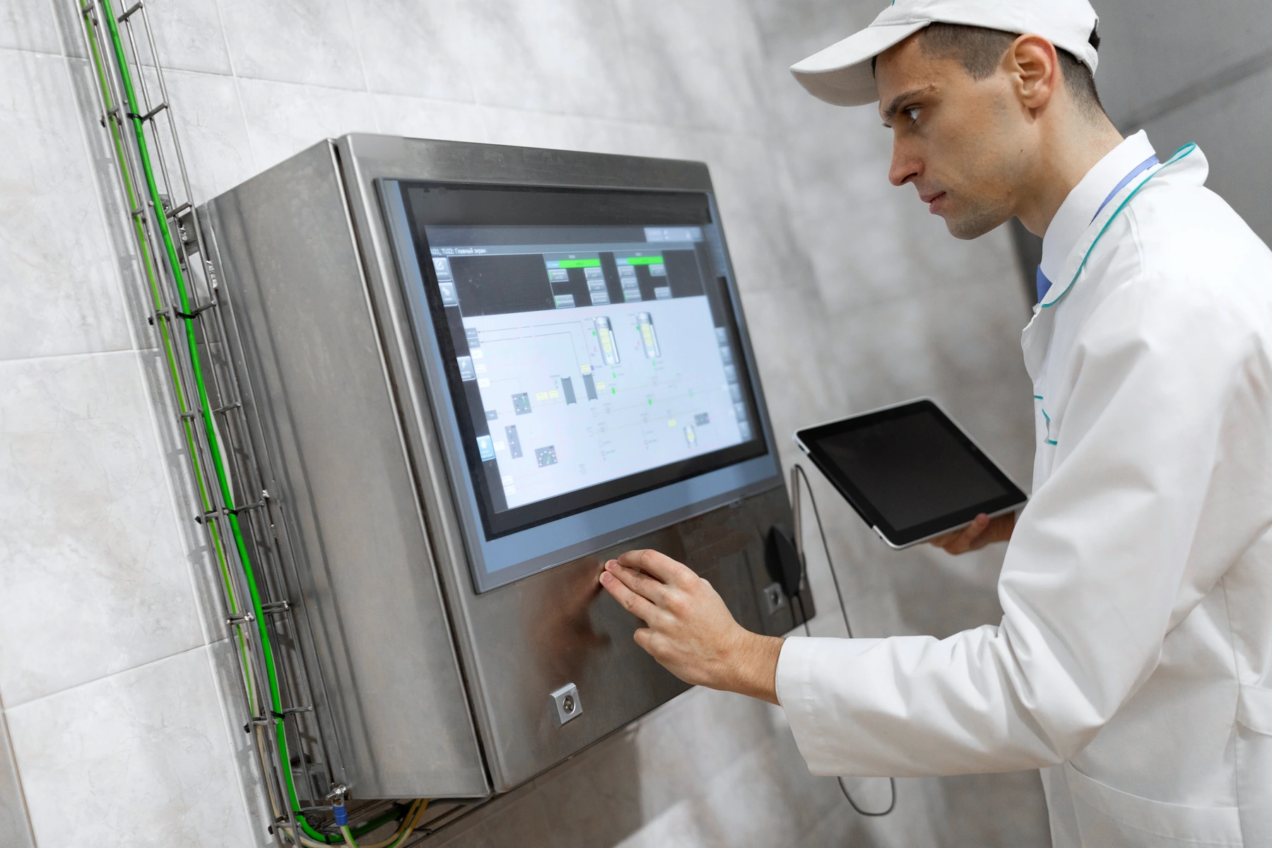 An operator uses a control panel on production equipment; beside it, a task card shows that filling on equipment AF-12 is waiting because the material inspection is still open.