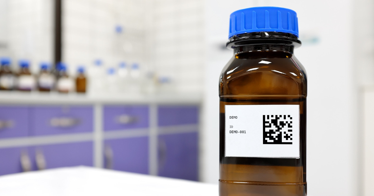 Brown laboratory bottle with a blue cap and an added Data Matrix code on its label
