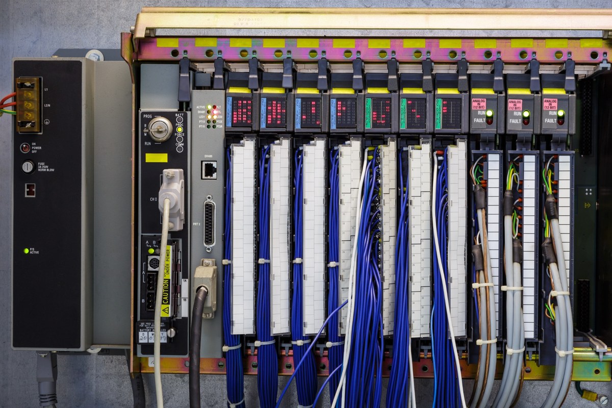 Industrial control architecture with a modular controller, I/O modules, and wired interfaces.